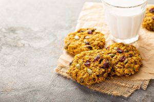 Trail mix cookies beside a glass of milk.