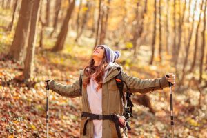 A woman hiking in a forest in autumn.