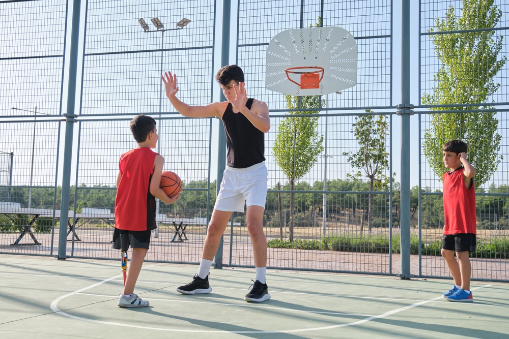 A group of boys playing basketball on an outdoor court.