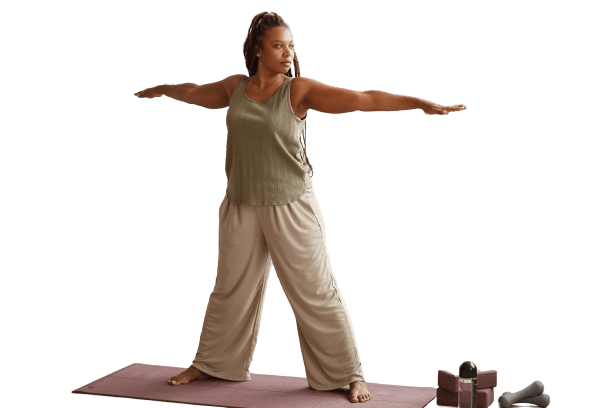 Woman with her hands out parallel to the ground standing on a yoga mat