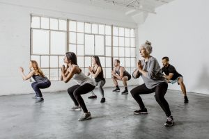 A group of adults exercising in a gym. Exercise improves brain health.